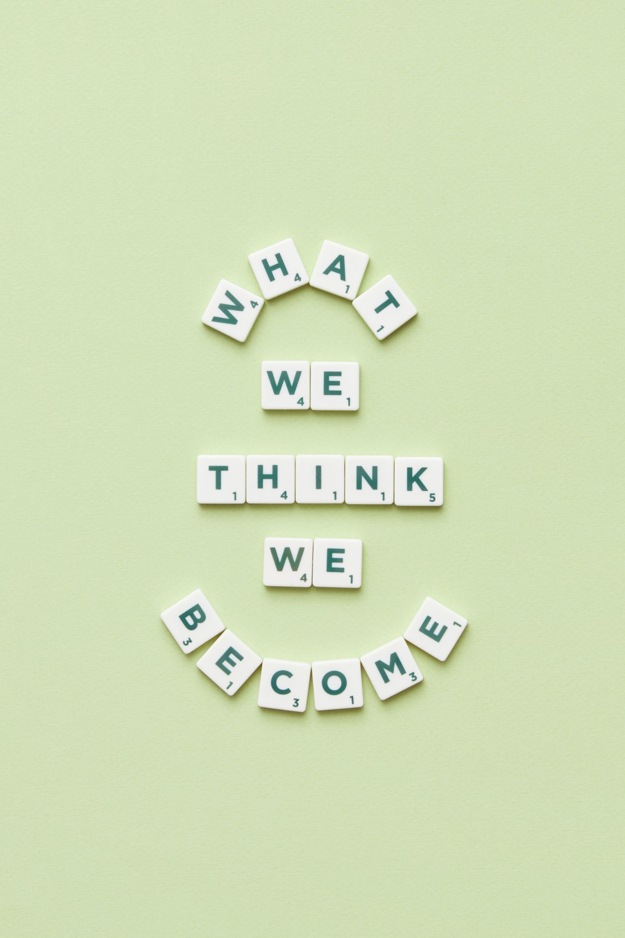 Σύνθεση με τουβλάκια Scrabble που γράφει What We Think We Become για τις σκέψεις και τη ζωή
